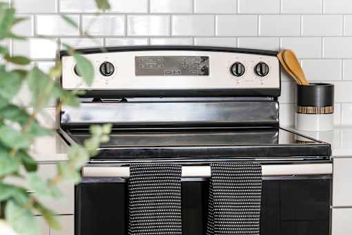 A black and white oven with a digital display and control panel.