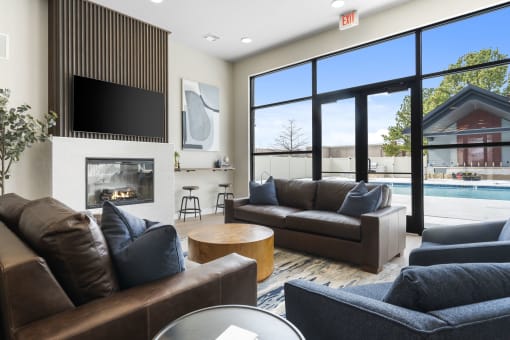 a living room with couches and a fireplace and a pool at The Junction at Rogers, Rogers