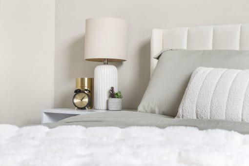 a white bed with white bedding and a white nightstand with a white lamp at The Junction at Rogers, Rogers, Arkansas