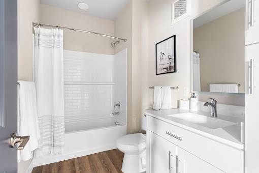 A white bathroom with a toilet, sink, and bathtub.