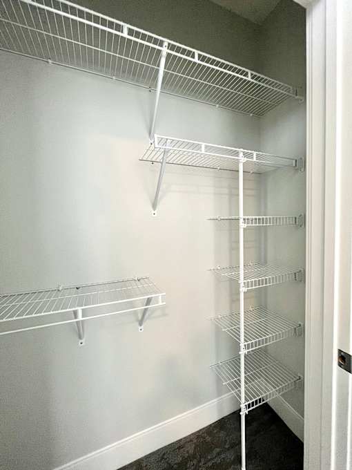 Empty white shelves in a pantry.