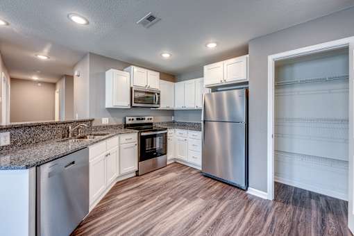 A kitchen with white cabinets and stainless steel appliances.