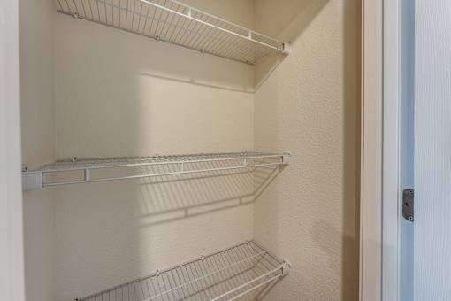 Empty shelves in a white refrigerator.