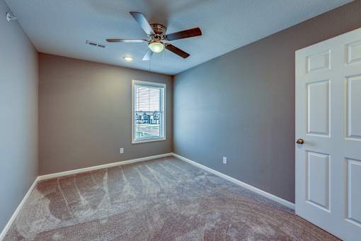 A room with a ceiling fan and a window.