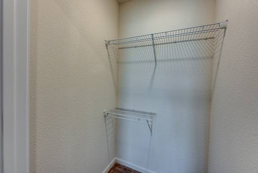 Empty wire shelving in a corner of a room.