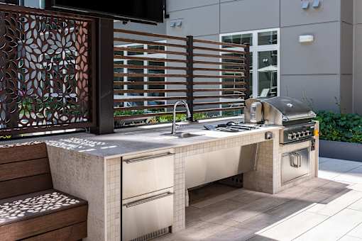 A modern outdoor kitchen with a grill and sink.