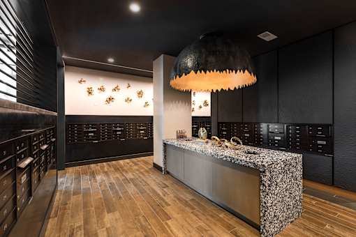 A modern kitchen with a wooden floor and a black ceiling light.
