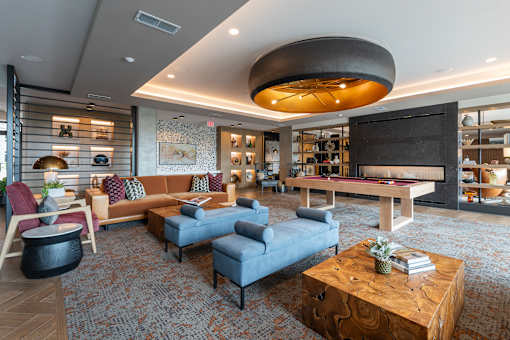 A modern living room with a curved ceiling and a pool table.