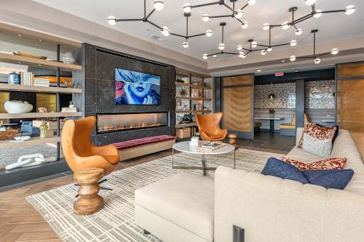 A modern living room with a large screen TV and a wooden sculpture on the coffee table.