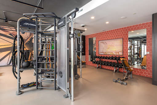 A gym with a red wall and a mirror.