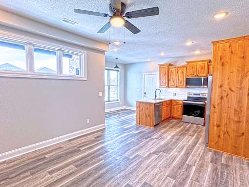 A kitchen with wooden cabinets and a ceiling fan.