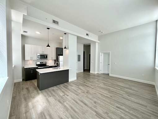A spacious kitchen with a bar area and a dining table.