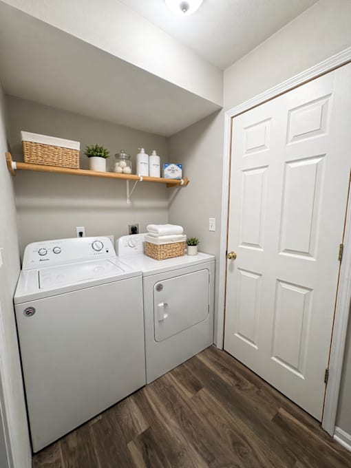 A white bathroom with a double sink and a white door.