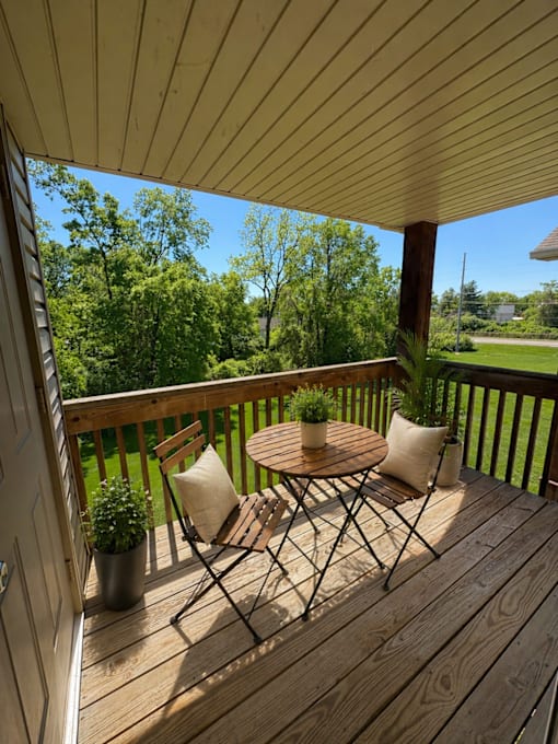 A wooden deck with a table and chairs overlooking a lush green yard.