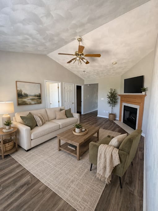 A living room with a couch, coffee table, and a fireplace.