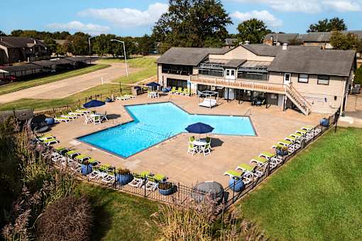arial view of a pool with a house in the background