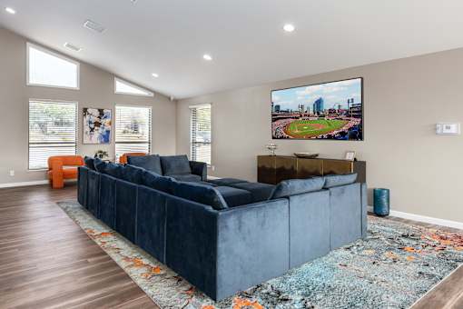 a living room with a blue couch and a tv on the wall