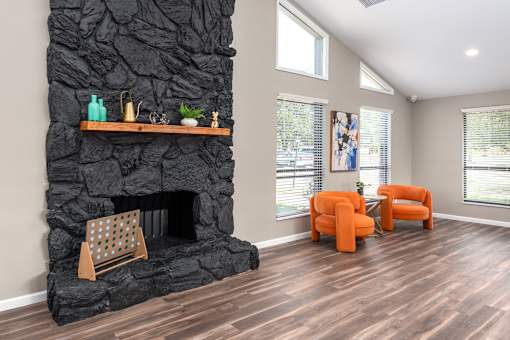 a living room with a fireplace and orange chairs