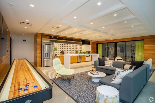Clubroom View including common space kitchen area, seating area, and shuffleboard table  at Grand Flats, St. Louis, MO, 63104