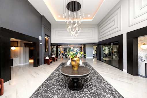 A large, elegant foyer with a marble floor and a chandelier at The Cunningham Apartments, Iowa