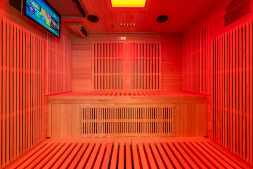 A room with wooden benches and a television mounted on the wall.