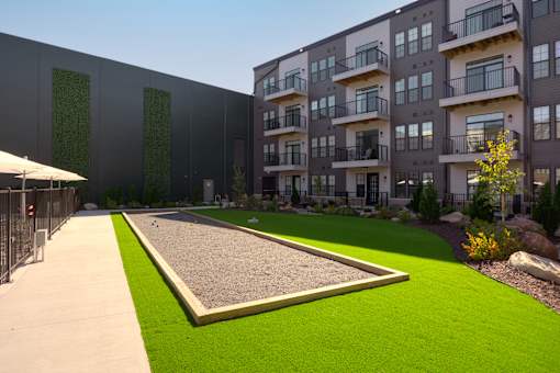 A modern apartment complex with a green lawn in front. at The Cunningham Apartments, West Des Moines, 50266