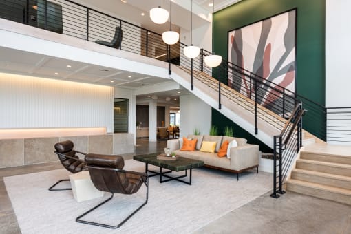 a living room with a staircase and a couch and a table at The Flats & Terraces at Wildhorse Village, Chesterfield