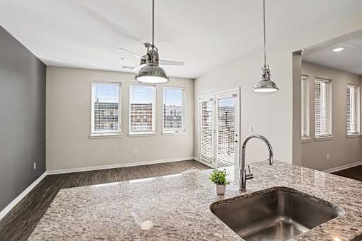 A kitchen with a granite countertop and a window view.