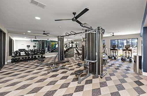A gym with a checkered floor and a variety of equipment. at The Cunningham Apartments, West Des Moines, Iowa