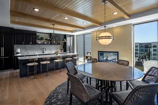 A modern kitchen with a wooden ceiling and a round dining table.