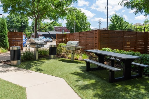 a picnic area with picnic tables and grills in a park at Grand Flats, St. Louis, 63104