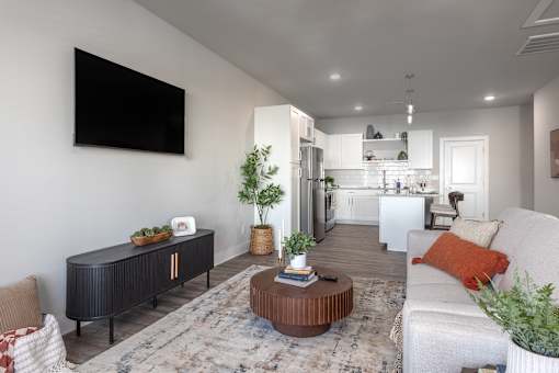 A modern living room with a flat screen TV mounted on the wall at Montage at Hawk Ridge Apartments, Lake St. Louis, 63367, Missouri