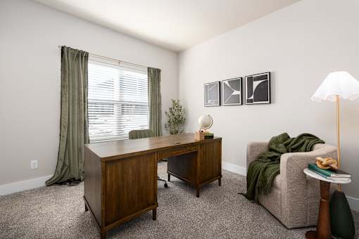A room with a desk, chair, and lamp at Hawk Ridge Apartments, Lake St. Louis, Missouri