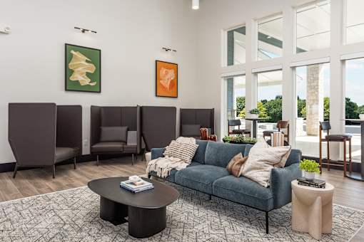 A living room with a blue couch and a coffee table at Montage at Hawk Ridge Apartments, Lake St. Louis, MO