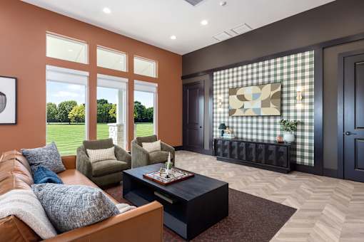 A living room with a brown couch, a coffee table, and a window with a view of trees at Montage at Hawk Ridge Apartments, 63367, Missouri