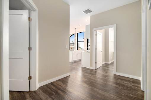A room with a white door and a window overlooking a cityscape.