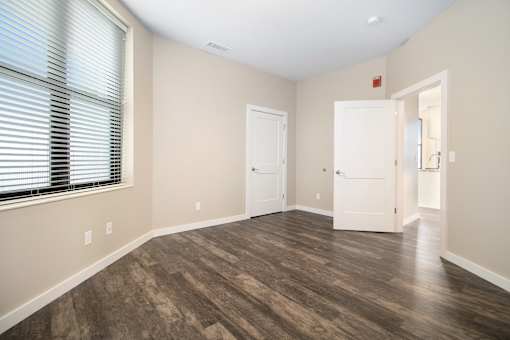 A room with wood flooring and two white doors.