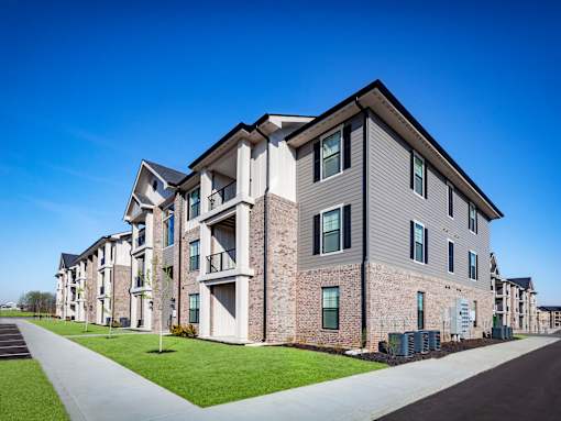 A modern apartment building with a clear blue sky above.