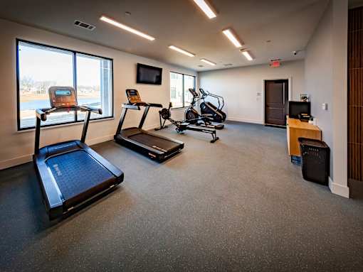 A gym with treadmills, exercise bikes, and elliptical machines.