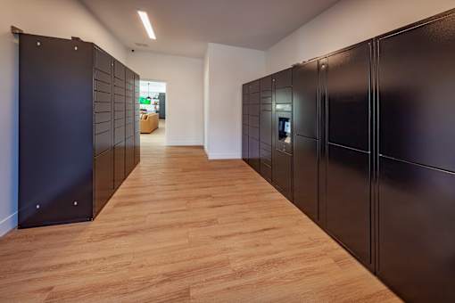 A long hallway with black doors and wooden floors.