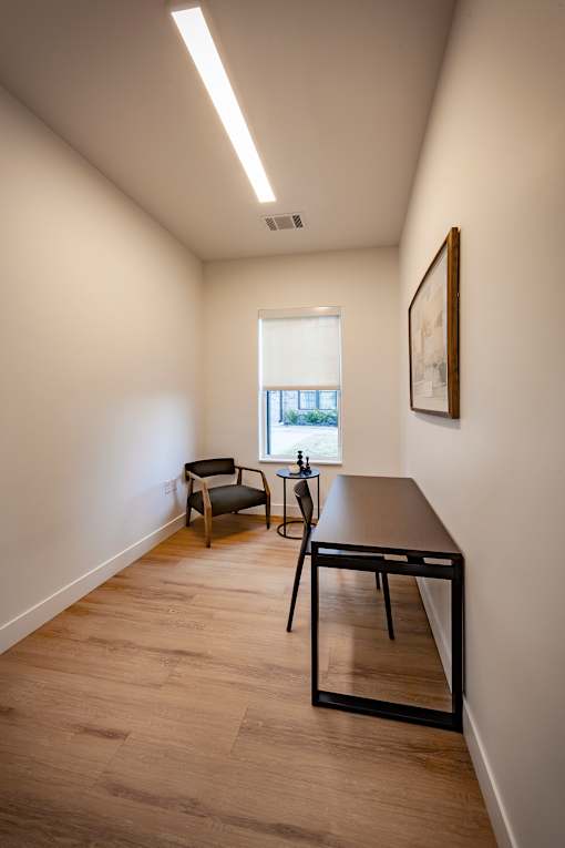 A room with a table and chairs and a window.