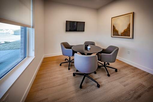 A conference room with a table and chairs.