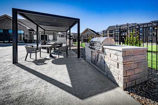 A patio with a table and chairs under a roof.