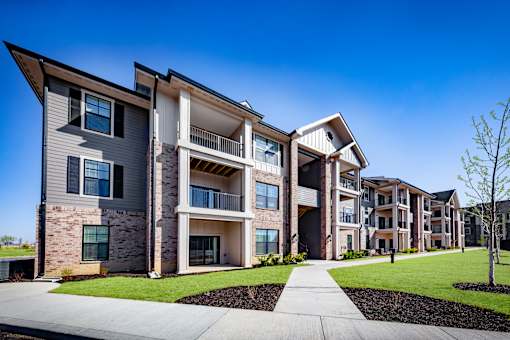 A modern apartment complex with a clear blue sky above.