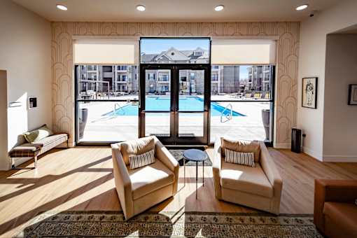 A living room with a pool outside the window.