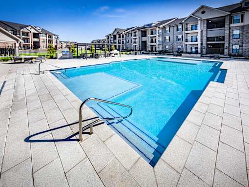 A swimming pool in a residential area with a clear blue sky.