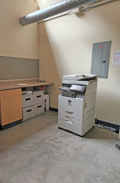 M Suites shared copy room with color copier and work shelf