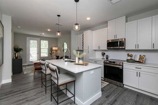A modern kitchen with a large island and stainless steel appliances. at The Cunningham Apartments, West Des Moines, Iowa