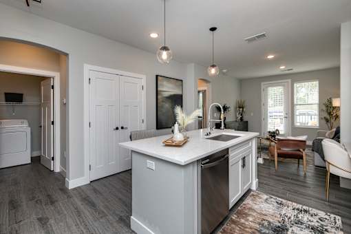 A modern kitchen with a large island and a dining area. at The Cunningham Apartments, West Des Moines, IA, 50266