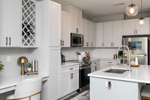 A modern kitchen with white cabinets and a white countertop. at The Cunningham Apartments, West Des Moines, 50266